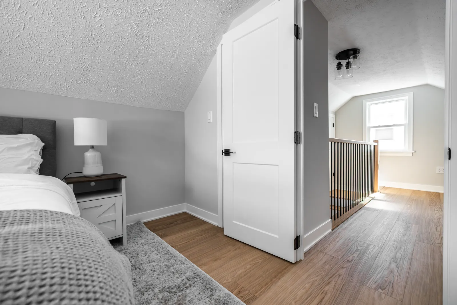 Bedroom doorway looking out to hallway and stair railing
